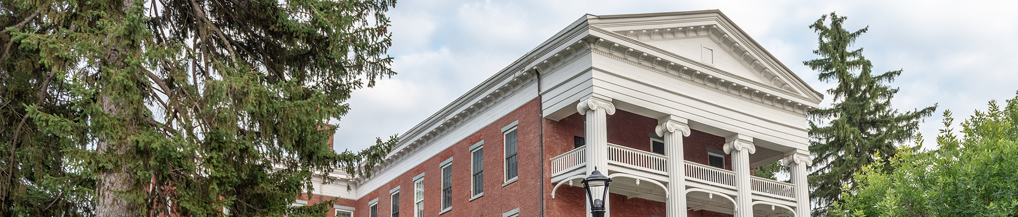 The front facade of Vassar-Warner Home surrounded by trees